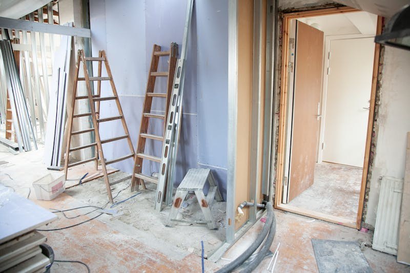 An apartment mid-renovation, with ladders and new framing in place